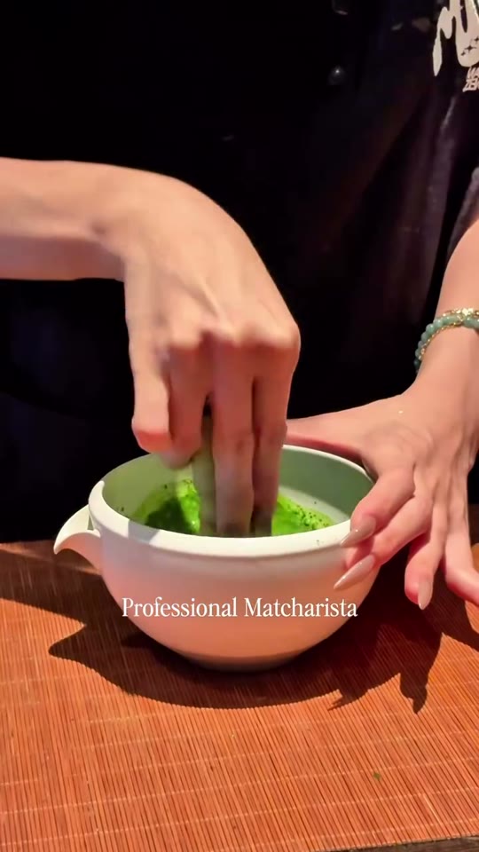 A barista whisks matcha in a ceramic bowl at Magicha Zenbar, a matcha specialty cafe in Da Nang.
